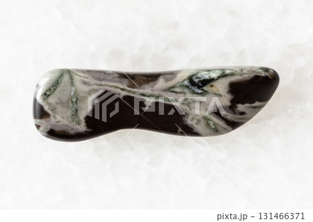 sample of tumbled hornfels rock on white marble sample of tumbled hornfels rock on white marble 131466371