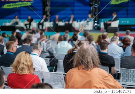 Business conference panel discussion as audience watches experts on stage Business conference panel discussion as audience watches experts on stage 131467175