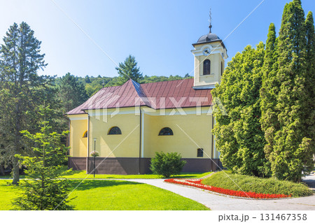 Bardejov Spa in North-Eastern Slovakia, Europe. Scenic view of a yellow building with a tower, set against a blue sky and lush greenery, evoking tranquility and architectural beauty. Bardejov Spa in North-Eastern Slovakia, Europe. Scenic view of a yellow building with a tower, set against a blue sky and lush greenery, evoking tranquility and architectural beauty. 131467358