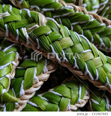 Intricate Thai style pattern of pandan leaf plait with thin white cotton stitches, showcasing vibrant green hues and traditional craftsmanship 131467683