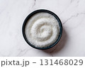 Monosodium glutamate in a dark blue bowl over marble kitchen counter. 131468029
