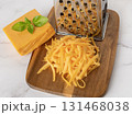 Whole and shredded cheddar cheese close-up. 131468038