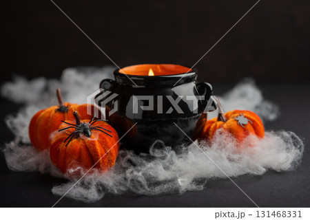 Halloween Candle in Cauldron with Pumpkins and Fog 131468331