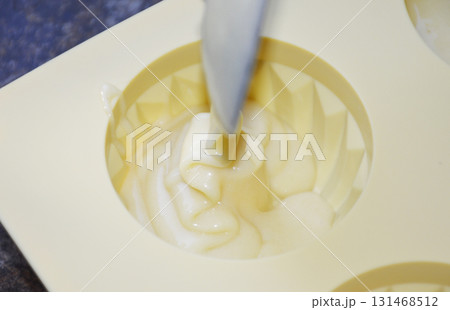 pouring liquid muffin batter into silicone baking mold pouring liquid muffin batter into silicone baking mold 131468512