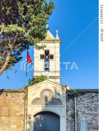 Historic bell tower and stone wall under a bright blue sky Historic bell tower and stone wall under a bright blue sky 131469431