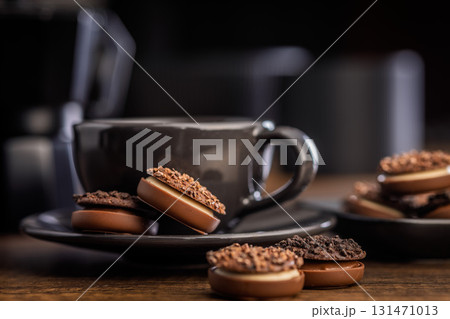 Sweet chocolate pralines. Chocolate candies and coffee cup on wooden table. Sweet chocolate pralines. Chocolate candies and coffee cup on wooden table. 131471013