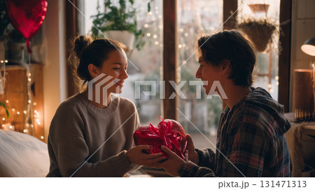 Couple sharing a heartfelt moment with a romantic gift in cozy room setting Couple sharing a heartfelt moment with a romantic gift in cozy room setting 131471313
