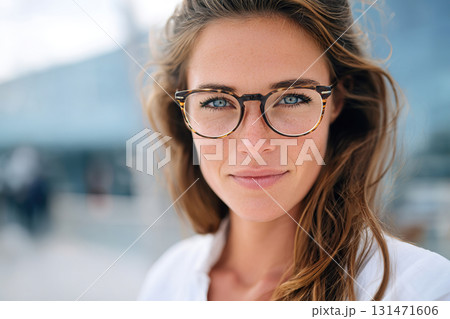 Confident young woman wearing stylish eyeglasses outdoors on a bright sunny day Confident young woman wearing stylish eyeglasses outdoors on a bright sunny day 131471606