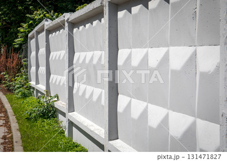 Modern Geometric Concrete Fence with Repetitive Pattern in Urban Green Surroundings 131471827