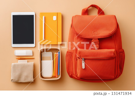 Bright orange backpack and school supplies set on a clean background for back-to-school prep 131471934