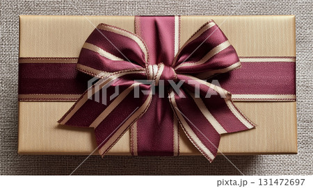ベージュのギフトボックスに結ばれた縞模様のボルドーリボンと蝶結び 131472697