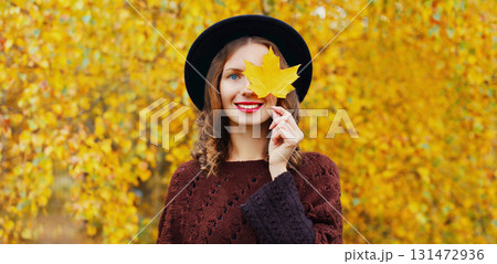 Autumn portrait of happy young woman with yellow leaves, cheerful girl smiling outdoors in park 131472936