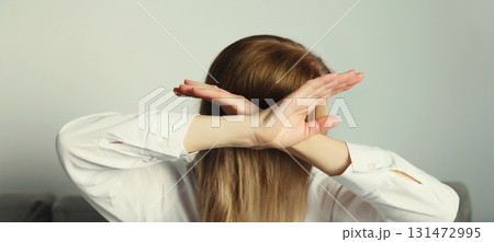 Woman shows stop, no or enough sign with palm of hand, refusal gesture, domestic violence 131472995