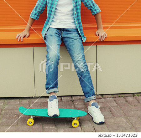 Modern teenage kid boy with skateboard in casual standing on city street 131473022