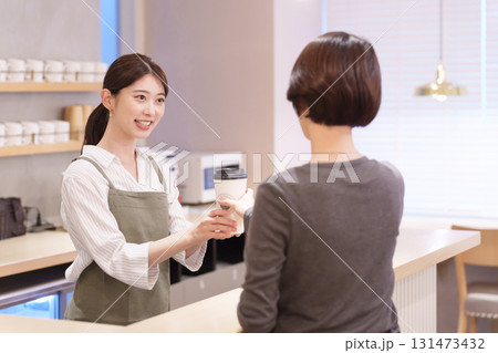 飲み物を客に渡すカフェ店員 飲み物を客に渡すカフェ店員 131473432