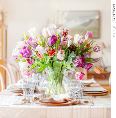 Easter concept. Glass vase bouquet pink yellow tulips, cradling pastel Easter eggs, set against modern grey backdrop. paste blank. Holidays, copy space, design greeting cards, art minimalist style Easter concept. Glass vase bouquet pink yellow tulips, cradling pastel Easter eggs, set against modern grey backdrop. paste blank. Holidays, copy space, design greeting cards, art minimalist style 131474344