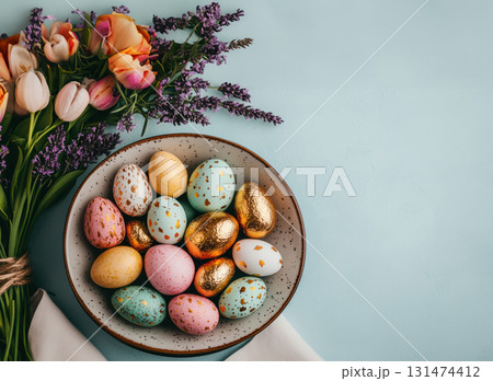 Happy Easter, banner Easter decorated table, blue table is plate with golden eggs, bouquet of various spring tulips, lily of valley flowers. 131474412