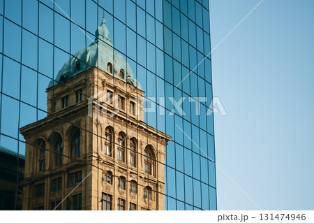 AI generated photograph showcasing the stunning reflection of a historic building on the sleek glass panels of a modern skyscraper. A fusion of architectural styles and light. 131474946