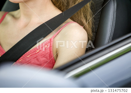 Young woman inside vehicle wearing protective seat belt. Safety and precaution concept. 131475702