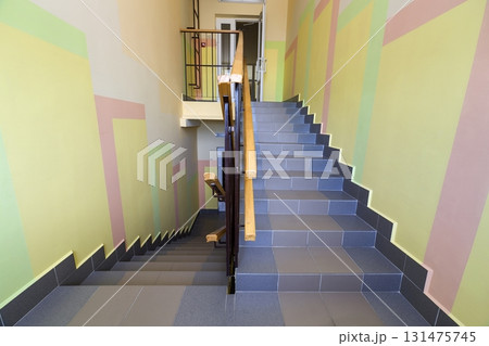 Wide staicase covered with ceramic tiles indoors in a house interior. 131475745
