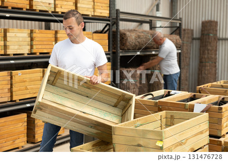 Young man choosing wooden box in store 131476728