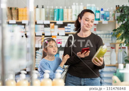 Woman scanning barcode on shampoo bottle Woman scanning barcode on shampoo bottle 131476848