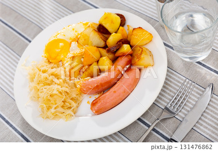 Sausages with egg and potatoes and cabbage 131476862
