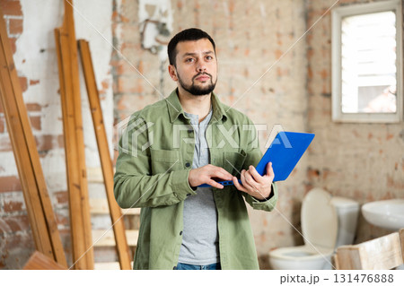 Man with laptop on indoor construction site Man with laptop on indoor construction site 131476888
