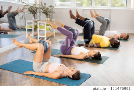 Group of men and women doing pilates with softball Group of men and women doing pilates with softball 131476991