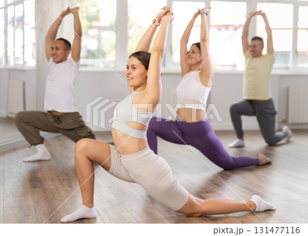 Cheerful young multinational people training synchronous group choreography in dance studio 131477116