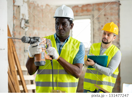 Confident builder posing on indoor construction site Confident builder posing on indoor construction site 131477247