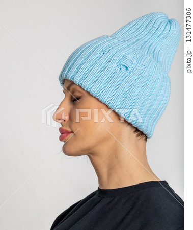Portrait beautiful woman in blue hat. Pretty girl in warm clothes on grey background. Studio photography. Vertical photo Portrait beautiful woman in blue hat. Pretty girl in warm clothes on grey background. Studio photography. Vertical photo 131477306
