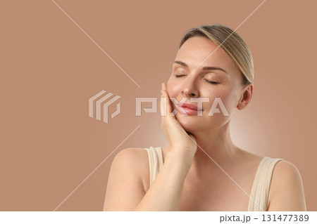 Woman applies skincare while relaxing in a quiet space 131477389