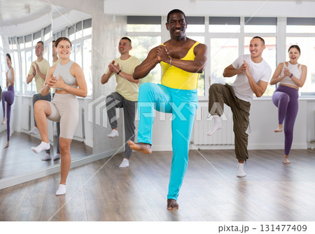 African american fitness trainer leading dynamic zumba class African american fitness trainer leading dynamic zumba class 131477409