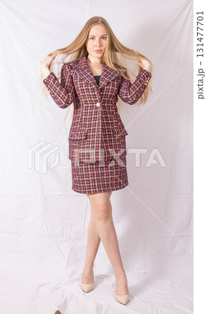 Positive businesswoman laughing while standing on white background. Beautiful young woman on tweed jacket. High quality photo 131477701