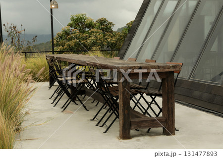 A group gathers at a rustic rooftop table with views A group gathers at a rustic rooftop table with views 131477893