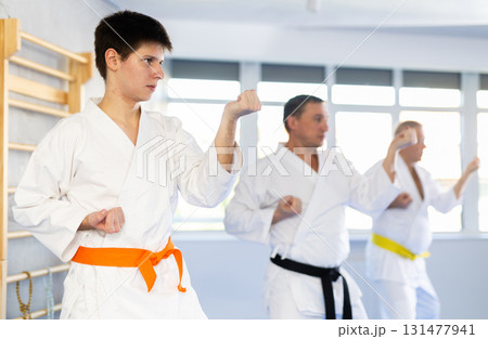 Fighting stance of men of different ages during group karate training. Guy trains punches 131477941