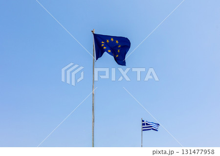 European Union EU and Greece flags is flying in air on blue sky background. Banner, place for text. High quality photo European Union EU and Greece flags is flying in air on blue sky background. Banner, place for text. High quality photo 131477958