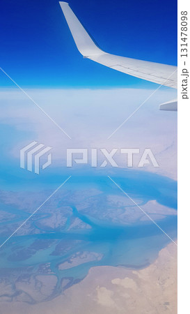 View from the window of plane on blue sky and earth with landscape of desert, sea and canals in Emirates. High quality photo 131478098