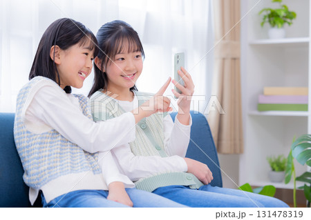 ファミリー スマホを見ている姉妹 ファミリー スマホを見ている姉妹 131478319