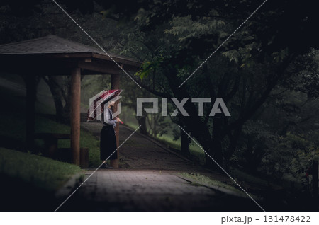 <素材>雨の森の中の公園を散歩する女性 <素材>雨の森の中の公園を散歩する女性 131478422