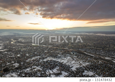 Top view of city suburbs or small town nice houses on winter morning on cloudy sky background. Aerial drone photography concept. Top view of city suburbs or small town nice houses on winter morning on cloudy sky background. Aerial drone photography concept. 131478432