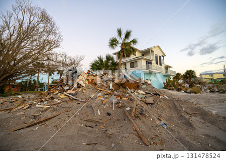 Rubbish and scrap disposed in heaps on street side after hurricane severely damaged houses in Florida home residential area. Consequences of natural disaster Rubbish and scrap disposed in heaps on street side after hurricane severely damaged houses in Florida home residential area. Consequences of natural disaster 131478524