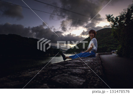 <素材>暗い夕暮れの海を一人散策する女性 <素材>暗い夕暮れの海を一人散策する女性 131478576