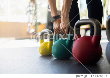 Athletic bodybuilding sport woman squat with kettlebell fitness training at gym Athletic bodybuilding sport woman squat with kettlebell fitness training at gym 131478683