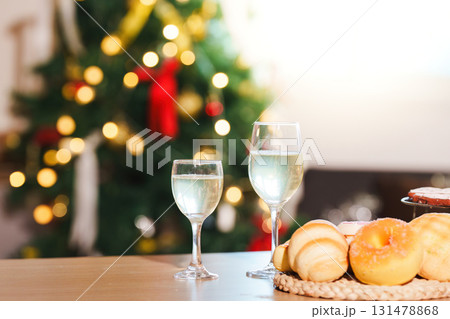 New Year Celebration. Sparkling drinks and pastries near a beautifully decorated Christmas tree. 131478868