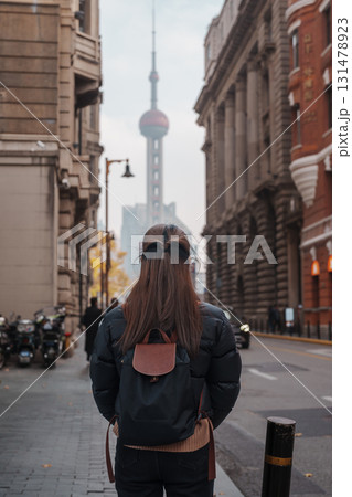 woman traveler visiting in Shanghai, China. Happy Female Tourist sightseeing Oriental Pearl Tower view in The Rock Bund of Shanghai. landmark and popular for tourism attractions. Travel and Vacation 131478923