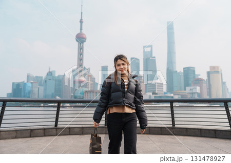 woman traveler visiting in Shanghai, China. Happy Female Tourist sightseeing Shanghai view of Lujiazui in The Bund of Shanghai. landmark and popular for tourism attractions. Vacation concept 131478927