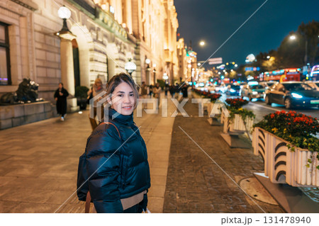 woman traveler visiting in Shanghai, China. Happy Female Tourist sightseeing Shanghai view in The Bund of Shanghai at night. landmark and popular for tourism attractions. Travel and Vacation concept 131478940