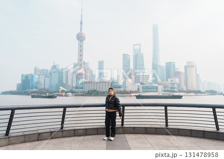 woman traveler visiting in Shanghai, China. Happy Female Tourist sightseeing Shanghai view of Lujiazui in The Bund of Shanghai. landmark and popular for tourism attractions. Vacation concept 131478958